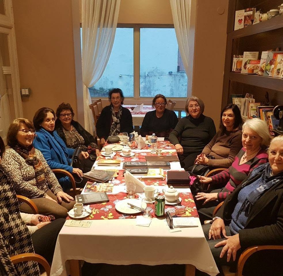 Mesa das seguidoras da Roda em sala com janela e estante, na apresentação da poeta Maria Carpi